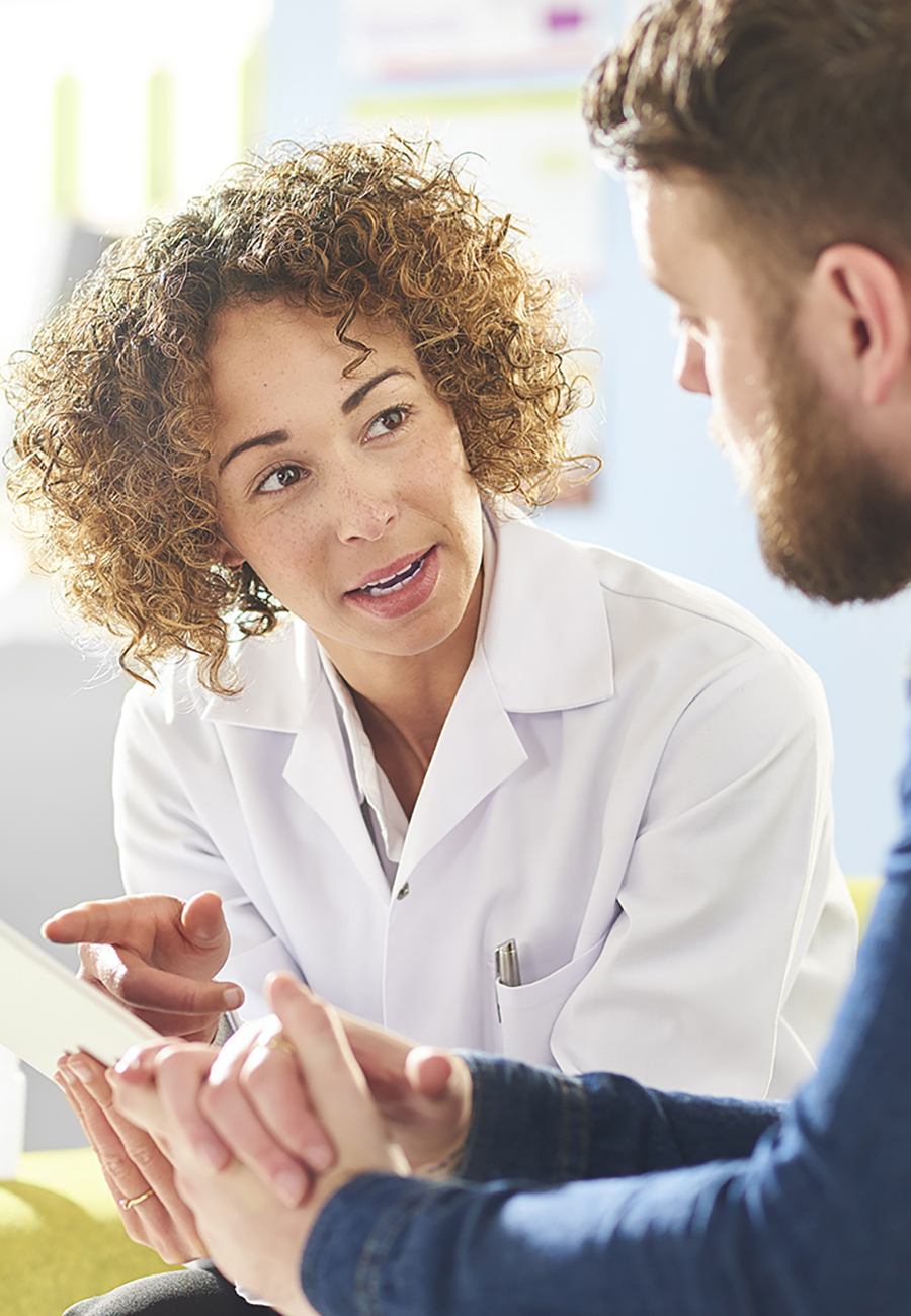 Doctor speaking with a patient while referencing a tablet