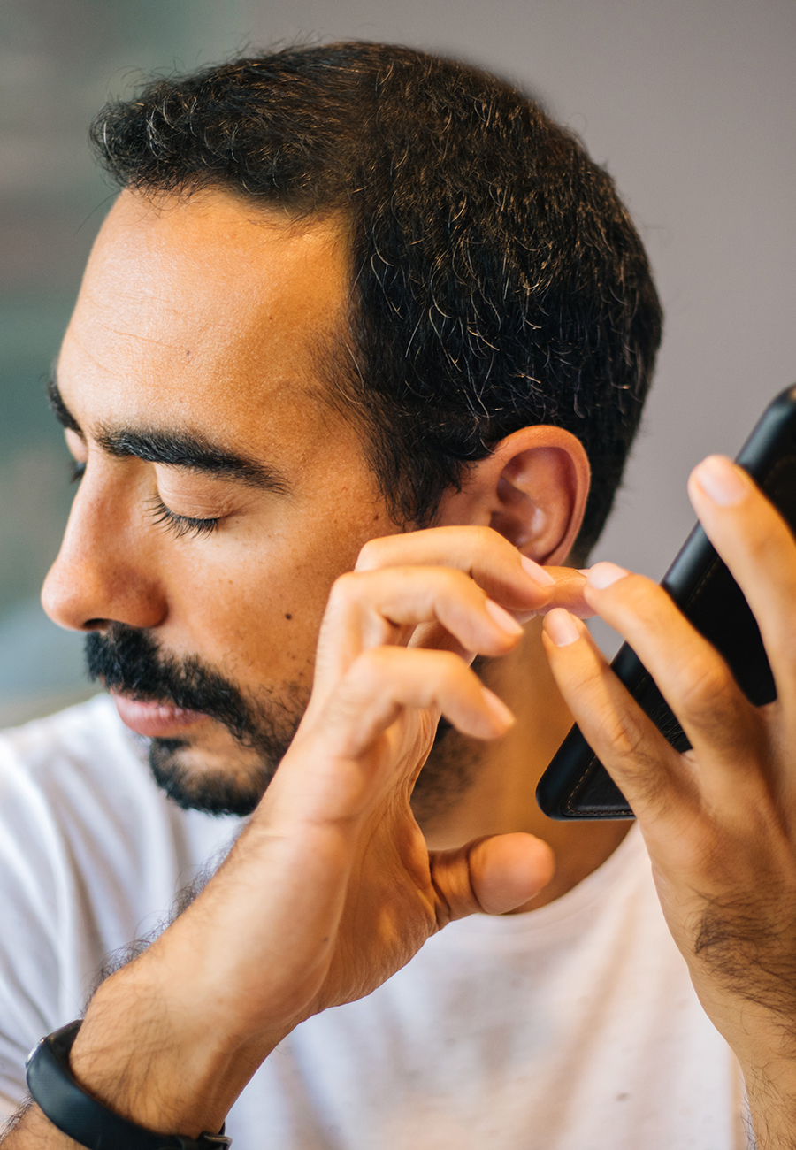 Blind man listening to speech outputs on a phone